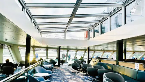 Large windows and a glass ceiling in the lounge of Havila Voyages