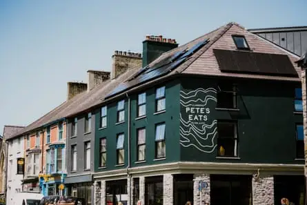 کافه ای در ردیفی از مغازه ها در روستایی در ولز.