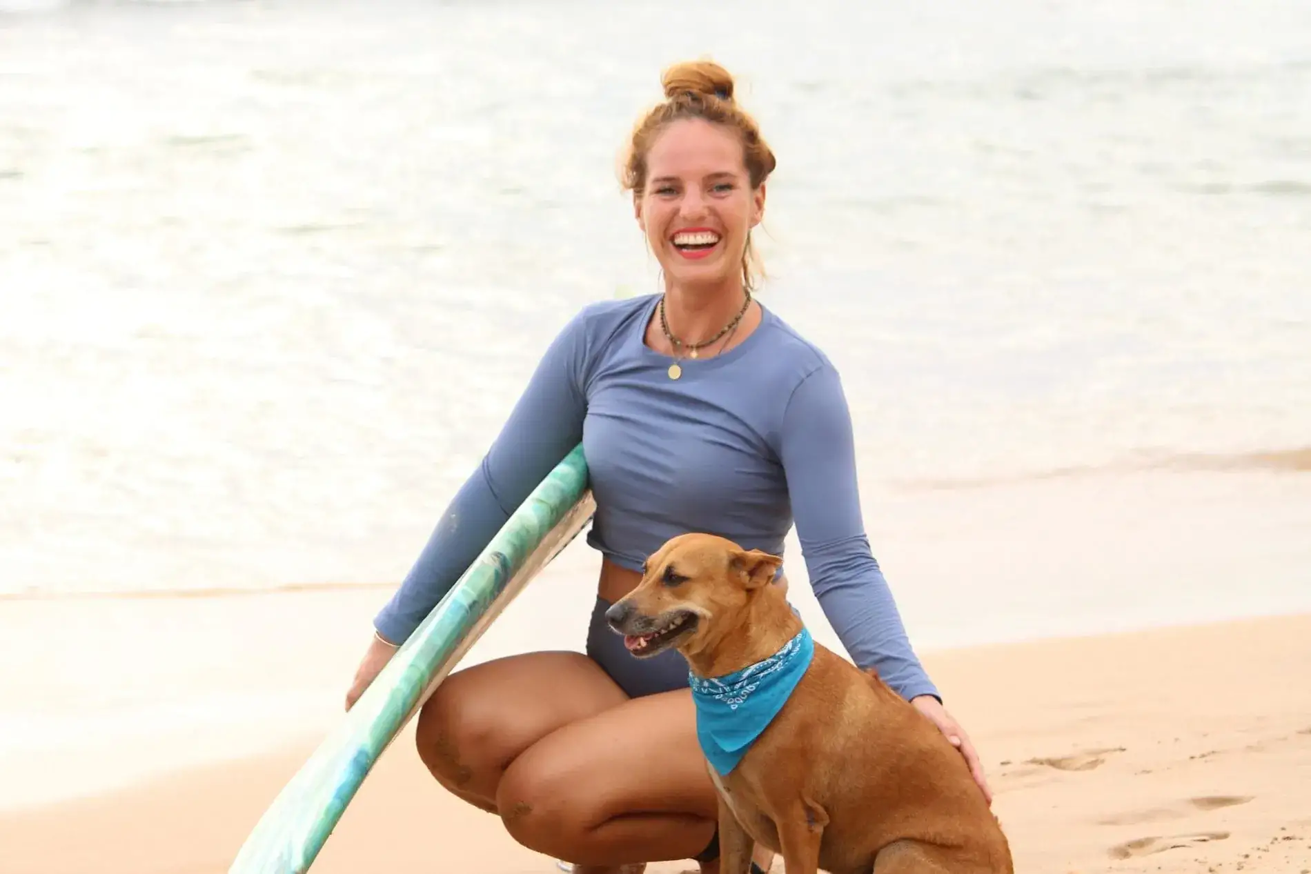 Franziska Pfähler mit Surfboard und ihrer Hündin Kiki am Strand von Hikkaduwa.