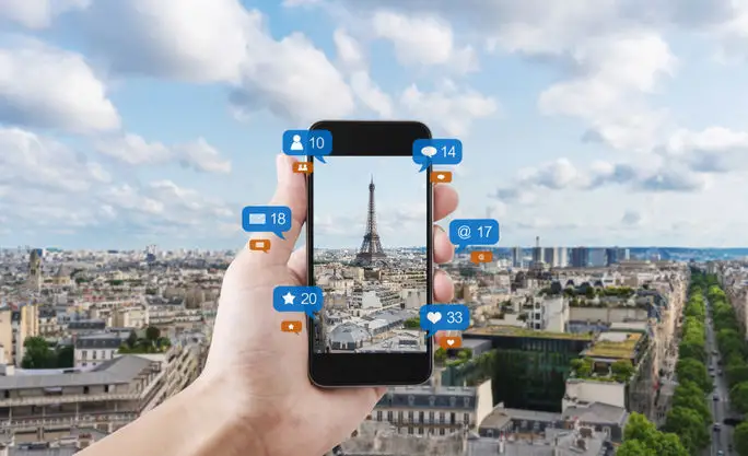 Smart phone taking a photo of the Eiffel Tower to post on social media.