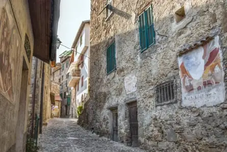 خیابان باریک سنگی با نقاشی‌های دیواری در امتداد دیوارها