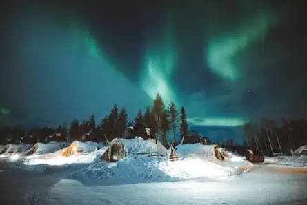 Snow, cabins, forest and the northern lights