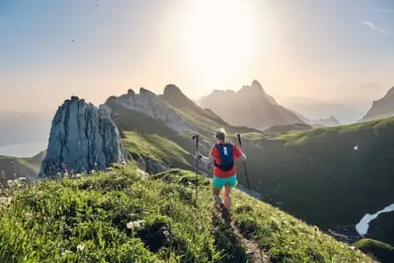 Female runner with poles in the Swiss Alps