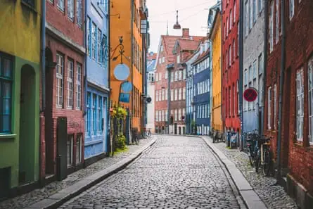 Narrow cobblestone alley with colorful houses in Copenhagen, Denmark