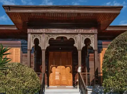 دو گربه در نور ملایم بعدازظهر روی پله‌های یک خانه چوبی تاریخی در بویوک‌آدا، استانبول استراحت می‌کنند.