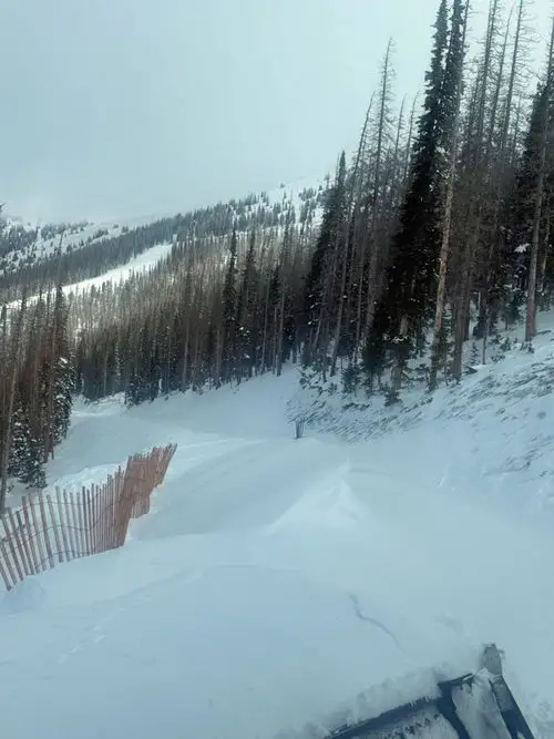 A temporary wind fence at Monarch Mountain has accumulated snow.