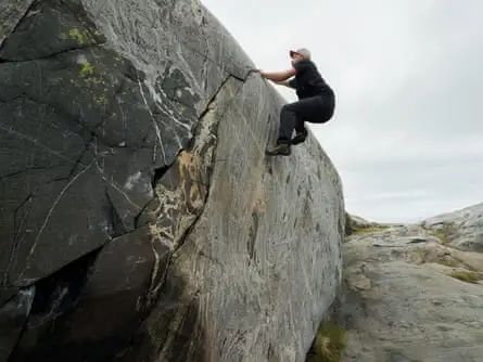 a climber scales a boulder 