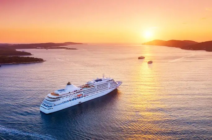 Cruise ship sailing into sunset