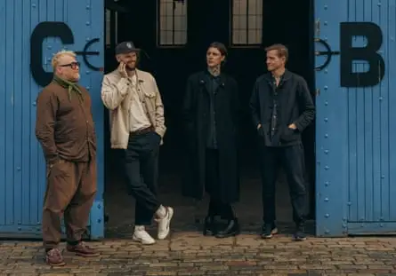 Four people standing outside warehouse doors